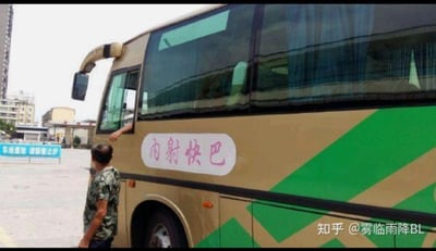 这是一张停车场场景的P图梗图，画面主体是一辆黄绿配色的大巴车，车身上被修改为带有低俗暗示的‘内射快巴’字样；车旁站着一位穿迷彩服的男子，车内有一只手臂伸出车窗，背景可见停车场的‘车场重地 请旅客止步’标识。
这是利用地名谐音制造的低俗双关梗，原本的线路名称应为‘内厝快巴’（内厝是福建等地的地名），被修改为不雅词汇，以此制造搞笑又低俗的效果。