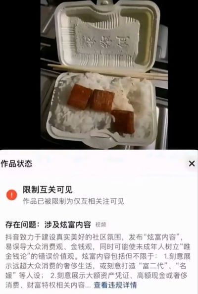 整张图为上下拼接的内容，上半部分是用户发布的视频里的内容：一份打开的白色一次性泡沫快餐盒，盒内盛有白米饭，米饭上仅摆放了3块方形的肉制品，一次性竹筷架在盒盖与盒身的缝隙处，盒盖内侧压印有“快餐盒”字样；下半部分是短视频平台抖音的作品状态通知页面截图，显示该条展示盒饭的视频被平台判定为涉及炫富内容，被限制为仅互相关注的用户可见，同时附带了平台关于禁止发布炫富内容的规则说明，内容反差强烈，充满讽刺搞笑效果。
