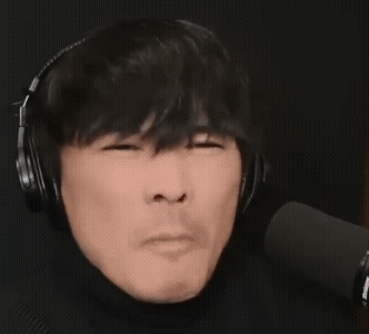 这是一张动态GIF图，呈现了一位佩戴黑色头戴式耳机的男性主播，他正处于麦克风前，看起来是在进行直播或音频录制的场景。该男性做出抿嘴的搞怪动作，面部肌肉向内收缩，神态滑稽又带点憋闷感，常被用作网络表情包，用来表达无语、憋笑、嫌弃、不想说话等情绪。