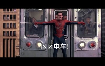 这是一张经过二次创作的影视截图，画面内容出自山姆·雷米执导的《蜘蛛侠2》，托比·马奎尔饰演的蜘蛛侠身着带有破损和污渍的经典红蓝战衣，面部狰狞紧绷，眉头紧皱、嘴巴紧抿，神情痛苦，显然已经用尽全身力气，他双臂张开，用蛛丝奋力拉住失控的城市电车，身体紧绷发力，电车车厢内的乘客也在关注着这一幕。画面底部添加了白色文字“区区电车！”，和蜘蛛侠吃力的状态形成强烈反差，制造出嘴硬、强行撑场面的搞笑效果，属于反差类的网络梗图，用来调侃那些明明已经力不从心却还要嘴硬装轻松的场景。
