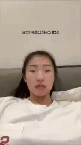 这是一张竖屏拍摄的真人照片，图中女生穿着白色上衣，神态平淡地看向镜头，画面上方加注英文文字“how i think i look like”（意为“我以为自己的样子”）。这类内容通常是“自我认知vs他人眼中的我”反差系列的前半部分，用来制造搞笑的自我认知反差效果，图中没有双关、谐音梗或暗示内容。