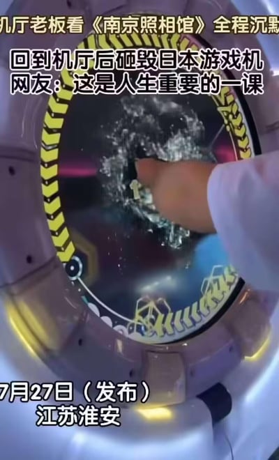 这是2024年7月27日江苏淮安发布的短视频截图，画面中一只手正砸向游戏机屏幕，屏幕已出现明显碎裂痕迹。配文信息显示，游戏厅老板观看《南京照相馆》后全程沉默，回到自己的游戏厅便砸毁日本产的游戏机，有网友评论称这是人生重要的一课。