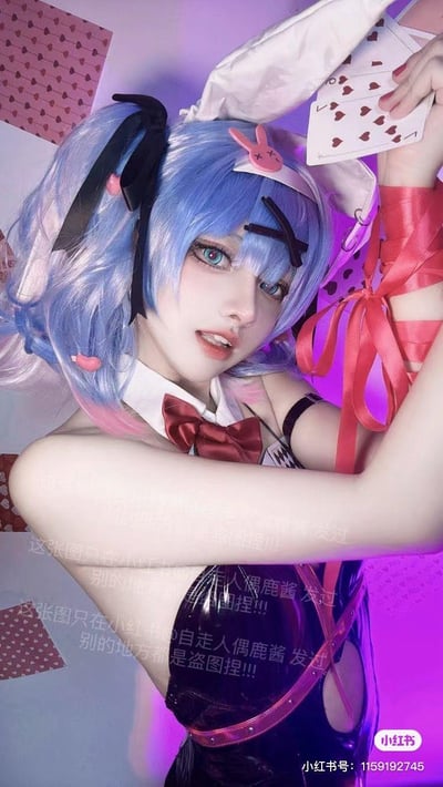 这是小红书用户@自走人偶鹿酱的原创初音未来兔女郎主题Cosplay照片，coser佩戴蓝粉渐变双马尾假发，搭配白色兔耳发饰与粉色兔子造型发夹，身着亮面黑色兔女郎服饰，搭配红色领结与白色立领，手臂缠绕红色丝带，手持红桃扑克牌。背景是带有爱心图案的粉色装饰，整体氛围被紫调霓虹光线渲染，造型兼具魅惑感与俏皮感。图中多处带有防盗图水印，标注该图片仅在小红书发布，其他平台出现均为盗图。