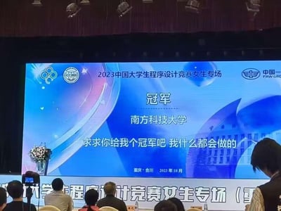 这是一张2023中国大学生程序设计竞赛女生专场的现场屏幕截图，屏幕原本正式公布冠军为南方科技大学，举办地点是重庆合川，时间为2023年10月，但被网友添加了“求求你给我个冠军吧 我什么都会做的”的搞笑配文，和严肃的竞赛颁奖场景形成强烈反差，制造出幽默的玩梗效果，画面下方能看到现场的观众，整体氛围正式又带着恶搞的趣味。