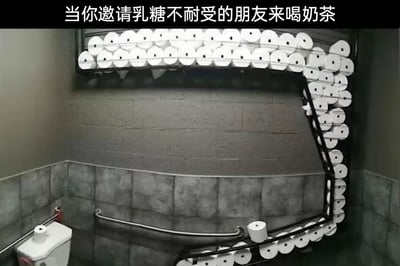 这是一张带有调侃性质的趣味梗图，画面顶部配有文字“当你邀请乳糖不耐受的朋友来喝奶茶”，主体内容是一个卫生间场景：墙面的金属架上挂满了数量极其庞大的白色卷纸，这些卷纸几乎在墙面上围成了一个大范围的区域，下方可见马桶和扶手。图中通过夸张地准备过量卫生纸的方式，调侃乳糖不耐受人群在饮用含有奶制品的奶茶后，会出现频繁腹泻的身体反应，需要频繁使用厕所和卫生纸的生活场景，用这种放大化的夸张设置来制造幽默效果，引发观者的共鸣和笑点。