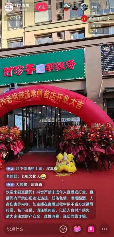 抖音直播间截图展示时珍香胡辣汤常州首店开业现场，店铺门头挂着绿色招牌，门口摆放红色拱门和花篮，地面铺着红地毯，还有舞狮道具。直播间评论区出现「尿真香」「老板文化人」等调侃留言，形成店名与评论的趣味呼应。