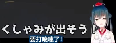 这是一张虚拟主播（Vtuber）的视频截图，画面右侧是一位有着蓝灰色长发、头戴红色小帽、身穿红白巫女风格服饰的日系虚拟主播，她眉头微蹙，嘴巴张开，面部神态呈现出即将打喷嚏的难受感。画面左侧配有日文文字「くしゃみが出そう！」，下方配有对应的中文翻译「要打喷嚏了！」，属于图文混排的形式，清晰传递出角色当下的状态，没有双关、谐音梗等特殊内容。