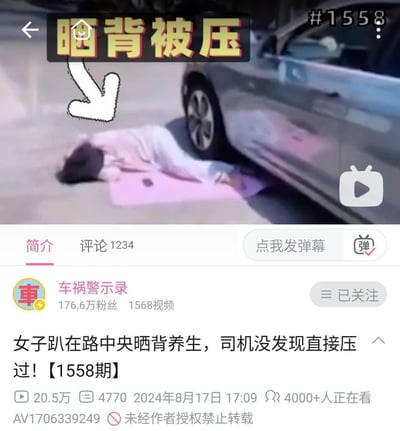 图片为一段警示视频的截图，画面中一名女子穿着浅色衣物趴在粉色垫子上，头朝地面，身体位于马路中央疑似晒背养生。其身旁停着一辆银色轿车，上方有醒目的黄色文字'晒背被压'及白色箭头指向女子。视频下方显示发布者为'车祸警示录'，简介文字说明'女子趴在路中央晒背养生，司机没发现直接压过！【1558期】'，旨在提醒公众注意此类危险行为，避免因不当养生方式引发交通事故。