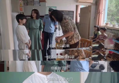 这是一张电视剧截图，展示了一个室内场景。画面中有多位人物：一位穿花衬衫的女性正在对一个男孩说话，旁边站着一位穿绿色连衣裙的女性和一位警察。背景中还有两个孩子坐在椅子上。房间布置有老式家具、黑板和窗户，营造出年代感。对话内容显示穿花衬衫的女性正在告诫男孩："你长大以后啊，一定不能搞数学科研，你看到了吗，只能给别人看大门"，暗示了对数学科研职业的负面看法。