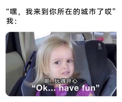 这是一张用于调侃社交敷衍场景的搞笑梗图。图中上方文字模拟他人发来的消息：“嘿，我来到你所在的城市了哎”，下方是坐在汽车安全座椅上的金发小女孩，她面露勉强、敷衍的神情，眼神透着不情愿，配文“呃...玩得开心”“Ok... have fun”，精准还原了收到他人到访消息后，内心并不想见面、只能勉强敷衍回应的心态，尤其契合社恐人群或不想应对额外社交时的情绪，中英双语的配文也让这个梗的传播范围更广。