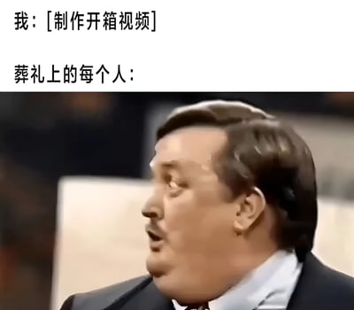 这张图片是一个网络迷因，分为上下两部分。上半部分有两行文字：第一行是'我: [制作开箱视频]'，第二行是'葬礼上的每个人:'。下半部分是憨豆先生（Rowan Atkinson饰演）的截图，他表情惊讶且困惑，侧头看向一边。该迷因通过对比'我'制作开箱视频的行为与葬礼场合的严肃氛围，利用憨豆先生的经典表情制造幽默效果，暗示不合时宜的行为引发的尴尬反应，引发观者共鸣与笑点。