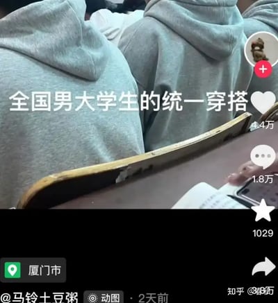 这张图展示了一间大学教室内，几位男生穿着相似的灰色连帽卫衣，画面配文“全国男大学生的统一穿搭”，幽默地调侃了大学男生穿着风格的单一化和集体化。整体气质偏向吐槽和自嘲，贴近大学生活日常，带点共鸣和轻松氛围。没有明显双关、谐音梗或暗示，幽默点在于把群体穿搭描绘成“统一制服”。