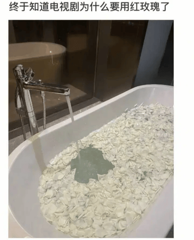 这张图展示了一个浴缸里铺满了白色的饺子皮，水龙头正往浴缸中放水，模仿影视剧里浪漫的花瓣浴场景，但饺子皮的视觉效果让画面瞬间变得滑稽。配文“终于知道电视剧为什么要用红玫瑰了”，玩了一个反差梗：如果使用白色的“花瓣”，泡在水中的样子会像煮饺子，完全没有浪漫感，以此调侃影视剧选择红玫瑰来维持浪漫氛围的原因。