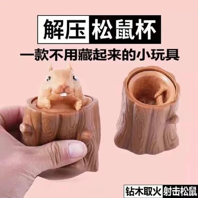 图片展示了一款名为“解压松鼠杯”的创意玩具。左侧为一只手握着树桩形状的杯子，杯中有一只可爱的松鼠玩偶探出身体；右侧是树桩杯子的空杯状态，可见内部结构。图片上方有醒目文字“解压松鼠杯”，下方配有“一款不用藏起来的小玩具”的说明，整体风格可爱，旨在宣传这款轻松有趣的解压小商品。