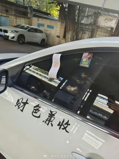 这是一张现实场景的实拍照片，主体为一辆白色轿车：车门上贴着“财色兼收”的黑色书法字体车贴，车窗上夹着一张带有红色公章的罚单，同时车窗内侧还贴有一张带女性形象的广告贴纸。背景中可见另一辆白色宝马轿车与老旧居民区的围墙。画面形成强烈反差感，车主打着“财色兼收”的口号，却先收到了罚单，充满现实讽刺的搞笑效果。