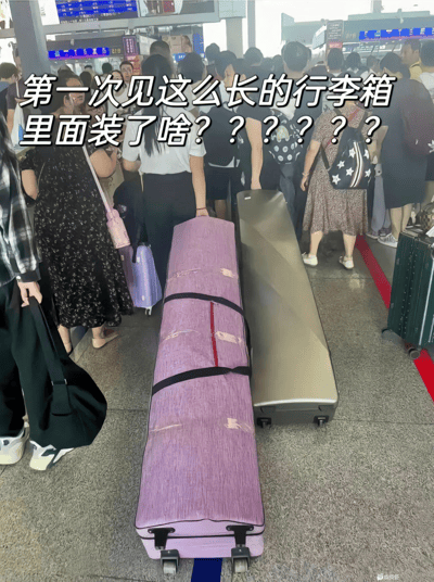 图片拍摄于一个交通枢纽（如车站或机场）的安检或入场区域，画面中可以看到人群排队等待安检，地面上非常显眼地放着两个超级长的行李箱，引发大家的极大好奇。图片中配有大字文案：“第一次见这么长的行李箱，里面装了啥？？？？？？？”语气调侃且略带悬疑。这个画面常被当作对未知事物的好奇或吐槽『有新奇稀有情况出现』时的表情包，也用来形容“谜一样的东西，想知道答案”，是典型的网友好奇心场景。没有明显双关或谐音梗，但有“带入猜测感 ”的幽默氛围。