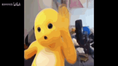 这是一段动态GIF，内容是国产卡通角色奶龙先是抬起一只手做出挥手的动作，随后放下手，脸上露出惊讶的表情，嘴巴张开、眼睛圆睁。背景是一个室内生活化场景，能看到桌椅、摆件等物品，整体画面风格软萌搞怪，生动呈现出打招呼后突然受惊的情绪，适合在社交聊天中用来表达惊讶、意外的心情。