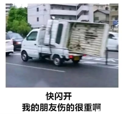 这是一张利用视觉错位制作的搞笑梗图。画面主体是一辆在城市道路上行驶的白色小型载货卡车，卡车的后挡板意外打开，倾斜着倚靠在路边的路杆上，从特定角度看过去，这个场景酷似一个人重伤倒地的模样。图片下方配有文字“快闪开 我的朋友伤的很重啊”，模拟出紧急送医时的呼喊，将货车故障的巧合场景包装成荒诞的“救友”剧情，通过视觉错觉和文字的反差制造出强烈的搞笑效果，在社交网络中用来以幽默的方式制造笑点。