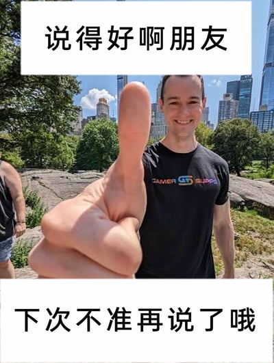 这是一张经过改编的网络梗图，利用视觉错位的拍摄手法，让前景人物伸出的大拇指看起来像是后方微笑男士的手，形成趣味视觉效果。图片上方配文“说得好啊朋友”，下方配文“下次不准再说了哦”，前后矛盾的文字内容制造出表面赞同、实则制止的反差感，常用于社交场景中调侃他人，表达口是心非的态度。画面背景是城市公园，还有其他路人出现在画面左侧，男士穿着印有“GAMER SUPPS”字样的T恤。