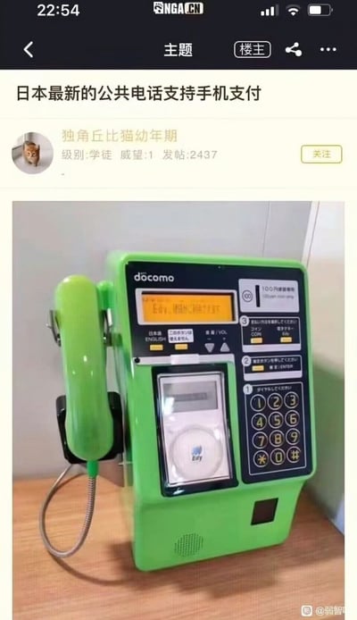 这张图片展示了一台亮绿色的日本公共电话，机身带有著名的docomo标志，显眼地配备了电子支付功能（Edy支付），画面文字吐槽‘日本最新的公共电话支持手机支付’，呈现出老旧设备与高科技支付结合的有趣反差。整体氛围带有一点时代错位的幽默和“科技改变生活”的意味，也透露出日本社会对于保留传统设施又逐步拥抱新技术的独特现象。该图在中文网络社区（NGA）被用户分享，体现了中国网友对日本细节文化的关注和调侃。