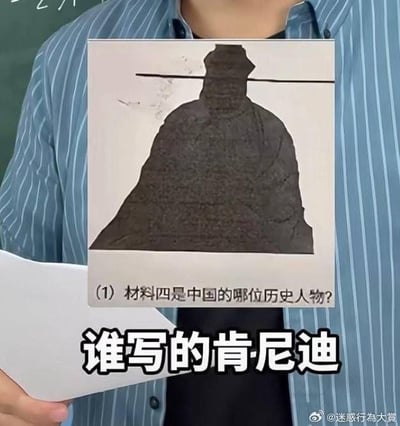 图片中一名身穿蓝白条纹衬衫的人手持一张印有历史人物剪影的纸张。纸张上的问题为：'（1）材料四是中国的哪位历史人物？'，下方剪影人物头戴长杆状帽子，身着宽大袍服，形似中国古代官员。图片底部叠加文字'谁写的肯尼迪'，通过将中国历史人物剪影错误关联美国前总统肯尼迪，制造出强烈的认知反差和幽默感，调侃可能出现的常识性错误或题目设计的迷惑性。