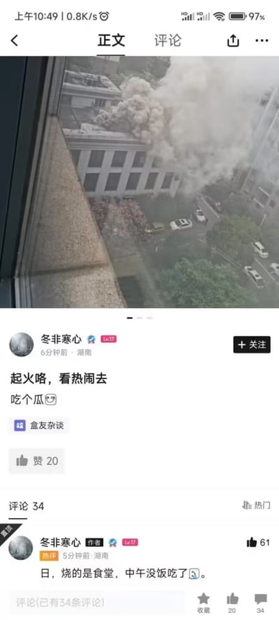 这张图片是一张网友社交平台截图，上半部分为高楼窗外的实拍，显示对面建筑发生火灾，大量白色浓烟从楼顶翻涌而出，下方是社交app内的动态和评论区。一位网友机智评论“起火咯，看热闹去，吃个瓜”，进一步评论中自嘲“日，烧的是食堂，午饭没得吃了”。评论流露出无奈和调侃，结合突发事件，将“吃瓜”一词用于现实生活，带有幽默和无奈的风格，在网络上具有传播性。

【暗示/双关】：
1. “吃瓜”原为网络用语，指围观他人事件，这里映射为实际生活中围观火灾，却发现烧的是自己需要的食堂，有无奈反转。
2. 评论流露出对突发事件的幽默自嘲。