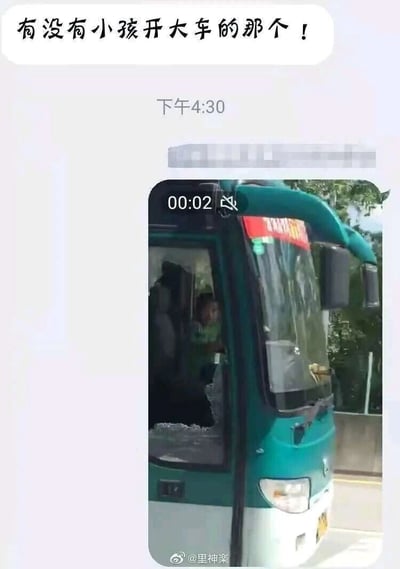 这是一张由聊天记录截图和视频截图拼接而成的竖屏内容，上方的聊天框内有网友提问“有没有小孩开大车的那个！”，下方是一段时长2秒的视频截图，画面中是一辆绿白相间的大巴车，车门位置的车窗呈破碎状态，一个小孩在车门区域，由于视觉错位的效果，看起来仿佛小孩坐在驾驶位“开大车”，实际是位置造成的视觉错觉，属于利用视觉误差制造的趣味搞笑内容。