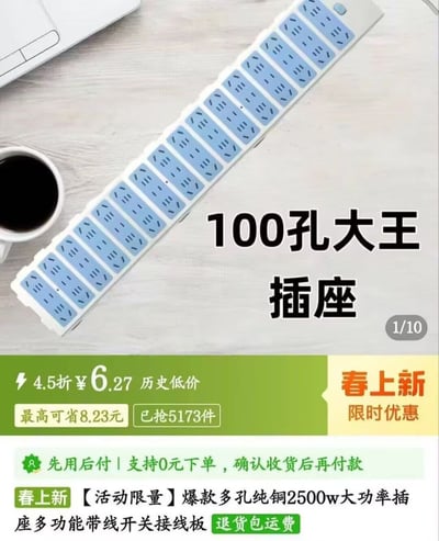 图片展示了一款被称为“100孔大王插座”的超长多孔插线板，插线板主体为白色，带有密集的蓝色插座孔位，横向延伸占据画面主要部分。背景为浅色木质桌面，左上角有一杯黑咖啡和一台笔记本电脑，营造居家或办公场景。图片右侧有大号黑色文字“100孔大王插座”，底部区域为绿色和黄色的促销信息栏，包含“4.5折¥6.27 历史低价”“最高可省8.23元 已抢5173件”“春上新 限时优惠”等字样，以及“先用后付 | 支持0元下单，确认收货后再付款”“【活动限量】爆款多孔纯铜2500w大功率插座多功能带线开关接线板 退货包运费”等详细促销描述。右上角标注“1/10”，表明这是系列展示图中的第一张。