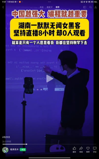 这是一张抖音平台的视频截图，画面中一位戴口罩的女生站在投影着代码的紫色背景前，用手机支架进行直播编程教学，却遭遇0人观看的窘境。配文强调「中国越强大 编程就越重要」，并介绍这位来自湖南的默默无闻女黑客坚持直播8小时无人观看，仍表示「就算是只有一个人愿意看我 我都会坚持教学下去」，整体画面传递出励志又带着些许无奈的氛围，展现了小众知识直播的现状。