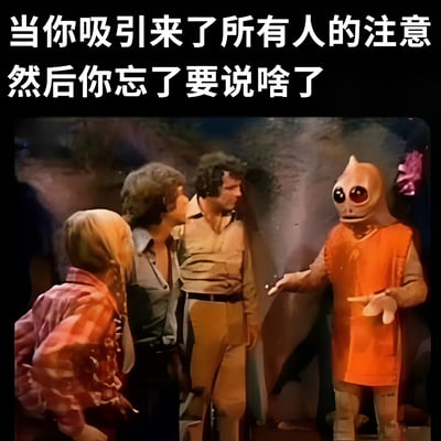 图片上方配有文字“当你吸引来了所有人的注意然后你忘了要说啥了”，下方是电影《E.T.外星人》的经典场景截图：外星生物E.T.穿着橙色衣服，伸出手指，表情茫然地面对几位围观的人类，生动展现了吸引全场目光后突然忘词的尴尬瞬间。