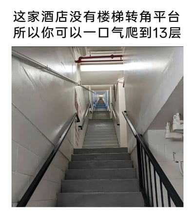 这是一张实拍的酒店楼梯照片，图中的楼梯没有设置转角平台，楼梯台阶一直向上延伸，视觉上形成了一条纵深很长的通道，配合上方的文字“这家酒店没有楼梯转角平台，所以你可以一口气爬到13层”，展现出这家酒店楼梯设计的独特之处。这样的楼梯设计可以让人不用转弯就能直达13层，但同时也会给爬楼的人带来不小的体力挑战，这种少见的建筑设计很容易引发人们对其实用性和趣味性的讨论。