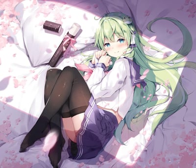 画面中是一位绿发蓝眼的少女，她身着白色水手服与紫色短裙，搭配黑色过膝袜，正侧卧在洒满樱花花瓣的白色床铺上。少女双手轻握放在脸颊旁，面带温柔微笑，眼神清澈动人。她的长发如流水般铺散在床面，发间还别着一个小巧的青蛙发饰。床头摆放着一卷系着粉色丝带的日式卷轴和一个黑色小盒子，为画面增添了几分雅致。整体色调以柔和的粉紫色为主，营造出浪漫唯美的春日氛围，阳光透过窗户洒在少女身上，更添温暖治愈之感。