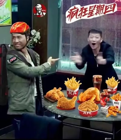 这是一张结合热门影视剧《狂飙》场景与肯德基品牌活动的二次创作梗图。图中左侧是被P成肯德基外卖员的老默（出自《狂飙》），面带笑意伸手指向满桌的肯德基餐品，包含整鸡、炸鸡块、薯条、可口可乐等；右侧的角色兴奋地拍手大叫，表情夸张。画面上方配有肯德基「疯狂星期四」的红色标语，用夸张的互动场景调侃大家对肯德基疯狂星期四优惠活动的期待与兴奋感，玩烂大街的疯狂星期四老梗。