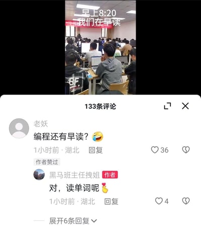 一张社交媒体截图，展示了一个坐满程序员的教室，所有人都在使用笔记本电脑。图片上方有文字标注"早上8:20 我们在早读"，暗示这是一个编程班的早读场景。下方评论区中，有用户质疑"编程还有早读？"，而作者"黑马班主任拽姐"回应称"对，读单词呢"。这一场景因为将传统语言学习的"早读"形式应用于编程学习而显得有些幽默和反差感。