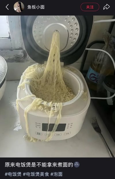 这是一张社交媒体发布内容的截图，画面主体为摆放在厨房台面上的白色电饭煲，电饭煲的锅盖处于掀开状态，大量煮熟的面条从锅盖中间的排气孔垂落到锅内，还有不少面条溢出到电饭煲的边沿、外壁，甚至掉落在台面上，场面十分离谱。截图底部配有发布者的配文“原来电饭煲是不能拿来煮面的”和一个惊恐表情，下方附带三个话题标签：#电饭煲、#电饭煲美食、#泡面，截图顶部显示发布该内容的用户名为“鱼板小面”，还有关注按钮和返回、分享按钮。