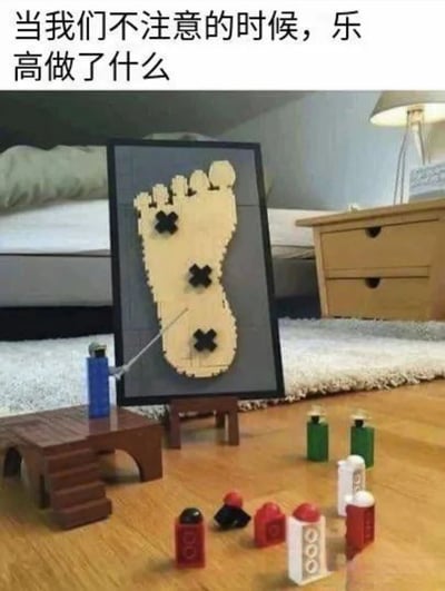 这张梗图展示了一个有趣的乐高场景：蓝色乐高小人正用棍子指向一幅由乐高积木拼成的脚形艺术作品，作品上有三个黑色叉号，暗示踩乐高时的痛点。地面散落着各种小乐高积木，配合上方文字'当我们不注意的时候，乐高做了什么'，幽默地调侃了乐高积木总是不经意间出现在脚下带来的疼痛，引发共鸣。