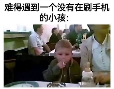 这张梗图由上方文字和下方图片组成，文字内容为“难得遇到一个没有在刷手机的小孩：”，下方是一张餐厅场景的照片，照片中一个小男孩正拿着疑似香烟的物品放在嘴边，表情严肃。图片通过反差制造幽默效果，讽刺了现代社会儿童过度使用电子产品的现象，同时也暗示了当孩子们不玩手机时，可能会做出一些出人意料的行为。