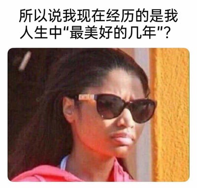 这是一张图文结合的表情包，上方配有吐槽文字“所以说我现在经历的是我人生中‘最美好的几年’？”，下方是美国说唱歌手妮琪·米娜戴着墨镜、皱着眉撇着嘴的抓拍图，人物神态充满嫌弃与烦躁。该表情包通过反讽的方式，精准传达出当下所经历的时光并不像外界定义的那样美好，满是对现状的无奈与吐槽，能够引发正处于压力期、对生活感到不顺的人群的强烈共鸣，常被用于社交媒体上抒发对生活的不满情绪。