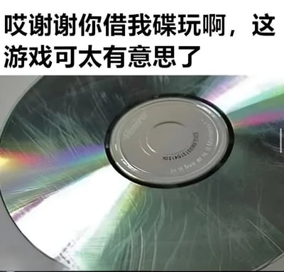 图片上方有一行黑色文字：“哎谢谢你借我碟玩啊，这游戏可太有意思了”，下方是一张特写照片，展示了一张表面布满密集刮痕的光盘，光盘在光线下呈现出彩色反光。图片通过文字表达的感谢与光盘严重损坏的视觉形成强烈反差，制造出幽默效果，暗示借碟者可能不小心刮花了光盘却故作轻松地感谢，带有调侃和尴尬的喜剧色彩。