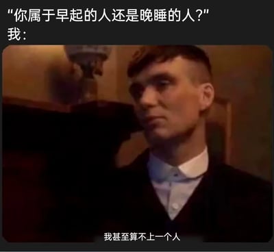 这是一张改编自英剧《浴血黑帮》截图的网络自嘲梗图，画面上方以提问“你属于早起的人还是晚睡的人？”引出话题，随后以“我：”衔接截图中的角色汤米·谢尔比，搭配底部字幕“我甚至算不上一个人”，用夸张且带有黑色幽默的自嘲方式，精准表达出当代人因长期作息不规律、熬夜或睡眠严重不足，导致身心状态极差，感觉自己脱离正常生活状态的情绪，借助剧中角色颓废疲惫的神情，进一步强化了这种状态下的无奈与自嘲感，容易引发有类似作息问题的网友共鸣。