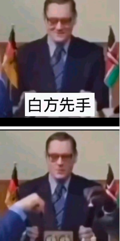 这是一张上下对比的梗图，上方图片显示一位戴眼镜的西装男子在新闻发布会发言，背景有德国国旗等旗帜，图片中央有白色文字框写着“白方先手”。下方图片中，同一位男子表情变得严肃，一只手正伸向他面前的讲台或麦克风。