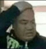 图片中显示一名男子，他正用右手抓着自己的头部，面部表情呈现出明显的懊恼或烦躁情绪。上身穿着一件深色夹克，衣服上有绿色的图案设计。背景较为模糊，无法清晰辨认具体环境，整体画面聚焦于人物的上半身动作和表情，没有可见的文字内容或水印。