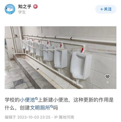 这是一张类知乎问答平台的用户帖子截图，用户“知之乎”（身份标注为学生，IP属地河南）于2023年10月3日发布该内容。帖子中包含一张校园卫生间的实拍图，图中显示在一排已安装好的小便池前方，又新增了一排更靠前的小便池，新小便池的管道是白色新管道，部分区域还拉了警示胶带。用户配文对这种改造提出疑问，疑惑在原有小便池旁新建小便池的作用，猜测是否为了创建文明厕所，该帖子收获了8个点赞，编辑时间为2023年10月3日23:25。