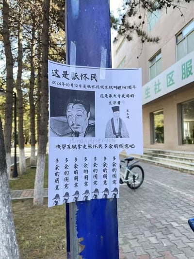 这是一张张贴在户外蓝色柱子上的自制趣味互动海报，以初中课文《记承天寺夜游》的典故为玩梗核心。海报标注2024年10月12日是张怀民被苏轼叫醒941周年，戏称张怀民是承天寺夜游的主导者，绘制了一脸困意、躺在床上的张怀民画像，以及苏轼的传统形象插画。海报下方手写小字“使其掉下陷阱(进垃圾桶)”，并设计了7张可撕下的小纸条，每张都写着“多余的困意”，呼吁大家“快帮苏轼拿走张怀民多余的困意吧”，用趣味互动的方式调侃这个经典古文场景，充满搞笑创意。