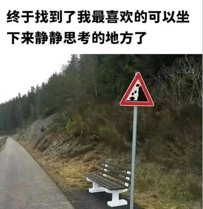 图片上方配有文字“终于找到了我最喜欢的可以坐下来静静思考的地方了”，下方是一张实景照片：一条乡村道路旁，有一个木制长椅，长椅旁边立着一个红色边框的三角形“落石警告”标志，标志内有黑色的落石图案。整体通过文字表达的“宁静思考”与实际场景中“落石危险”的强烈反差制造幽默效果。
