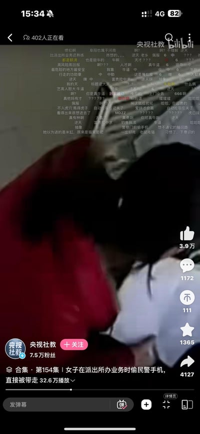 这是一张B站视频截图，显示了一名女子在派出所办理业务时偷窃民警手机被当场抓获的监控画面。视频来自"央视社教"账号，标题为"女子在派出所办业务时偷民警手机，直接被带走"，已有32.6万播放量。画面上方有大量弹幕评论，网友们纷纷表示震惊和嘲讽，使用了"人才"、"666"、"这操作秀啊"等网络热词表达对该女子行为的不解和讽刺。