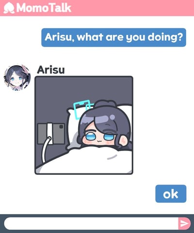 这是一张模仿MomoTalk聊天界面的表情包，上方对话框向爱丽丝（Arisu）提问“Arisu, what are you doing?”，爱丽丝回复了一张自己躲在被窝里、躺在床上用支架看平板的Q版插画，神态慵懒脸颊泛红，显得十分可爱，最后提问者回复“ok”，整体是轻松日常的可爱互动场景，没有双关或谐音梗。