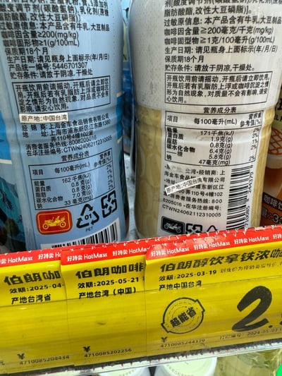 这是在折扣零售品牌好特卖（HotMax）的货架上拍摄的伯朗即饮咖啡商品图，画面展示了两款不同包装的伯朗咖啡瓶身标签，以及对应货架的黄色价签。
瓶身标签详细标注了咖啡的配料、过敏原信息（含牛乳、大豆制品）、咖啡因含量≥200mg/kg、咖啡固型物≥1g/100mL、保质期18个月、贮存条件、营养成分表，还标明产地为中国台湾，经销商为上海金车食品销售有限公司；
货架价签则标注了不同款伯朗咖啡的效期（2025-04、2025-05-21、2025-03-19）、产地、价格，价签带有“超能省”标识，显示打印编号和日期2024-05-03。
