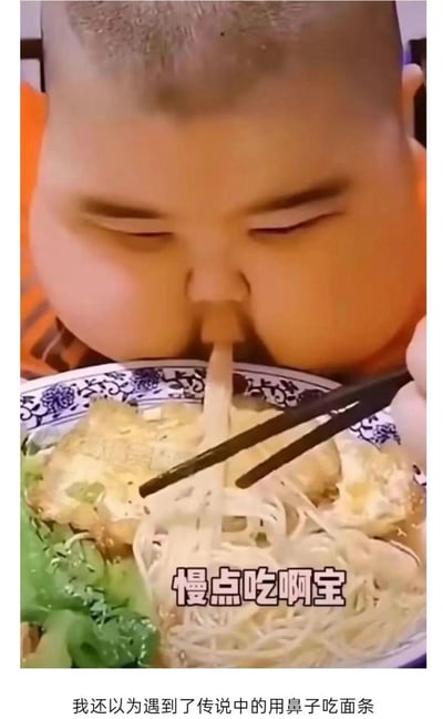 图中是一位名叫阿宝的胖小孩正低头吃面条，由于面条的位置恰好和小孩的鼻子对齐，形成了“用鼻子吸面条”的视觉错觉，制造出滑稽的效果。画面里的面条碗中配有煎蛋和青菜，图中有文字“慢点吃啊宝”，下方配文“我还以为遇到了传说中的用鼻子吃面条”，用这个巧合的错位场景来制造搞笑的笑点，让人忍俊不禁。