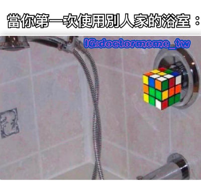 图片上方有文字“當你第一次使用别人家的浴室：”，下方是浴室淋浴区域的照片，原本的淋浴控制把手被替换成了一个彩色的魔方。通过将复杂难用的淋浴控制比喻成需要解谜的魔方，幽默地表现了第一次使用他人浴室时面对陌生淋浴设备的困惑与无奈。